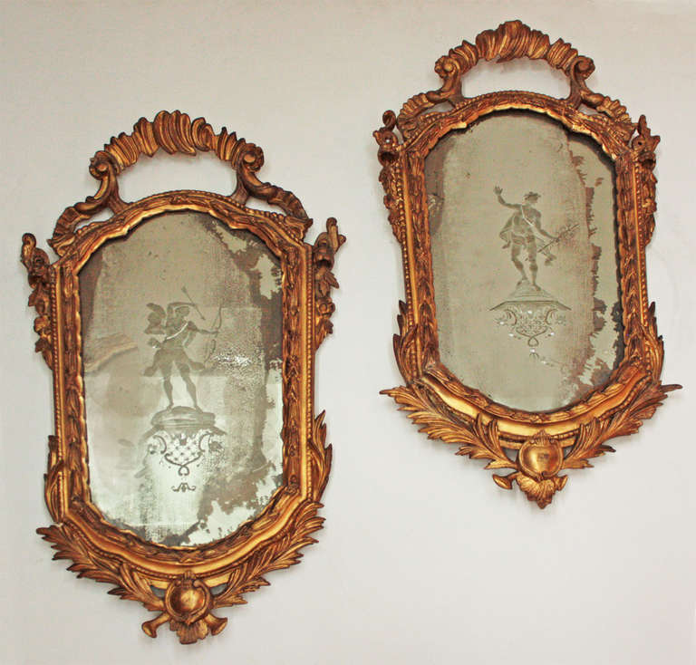 Pair of Venetian mirrors, carved and gilded with etched images on each mirror plate.

One an archer with bow and arrows, the next a man with a staff entwined with flowers.
