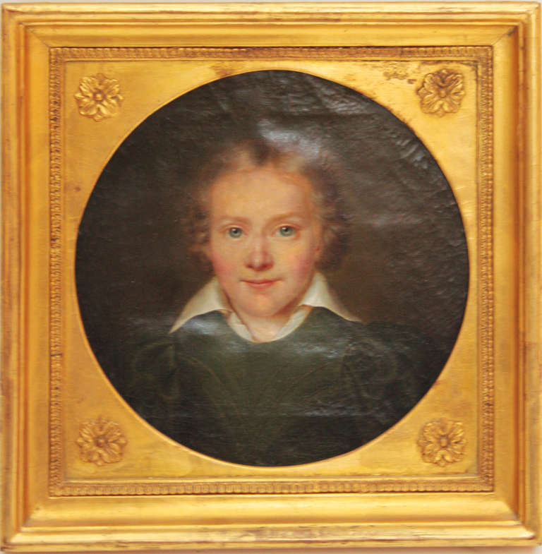 A small portrait of a young boy. Framed in gilt frame with round center showing boy. Identified on reverse.