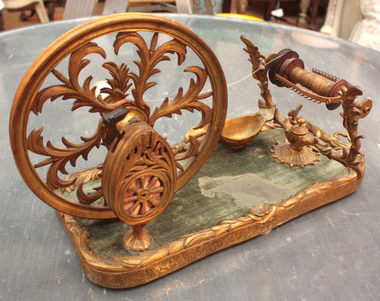 an elaborate gilt bronze table top spinning wheel

Image 8 (provided by tailor Mark Hutter of the Colonial Williamsburg Foundation) shows an English lady with a similar spinning wheel made of wood

several period English references were provided