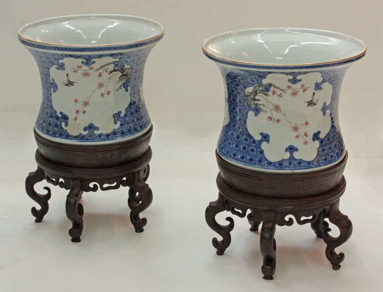 a pair of Chinese porcelain jardineres, white with floral pattern and blue, custom carved stands

6