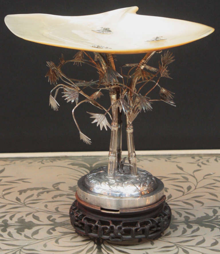a tazza with a sterling chased base holding three (3) bamboo canes with many leaves naturalistically rendered, all finely cast and engraved silver, topped with a mother-of-pearl shell decorated with three (3) butterflies that attach it to the base,