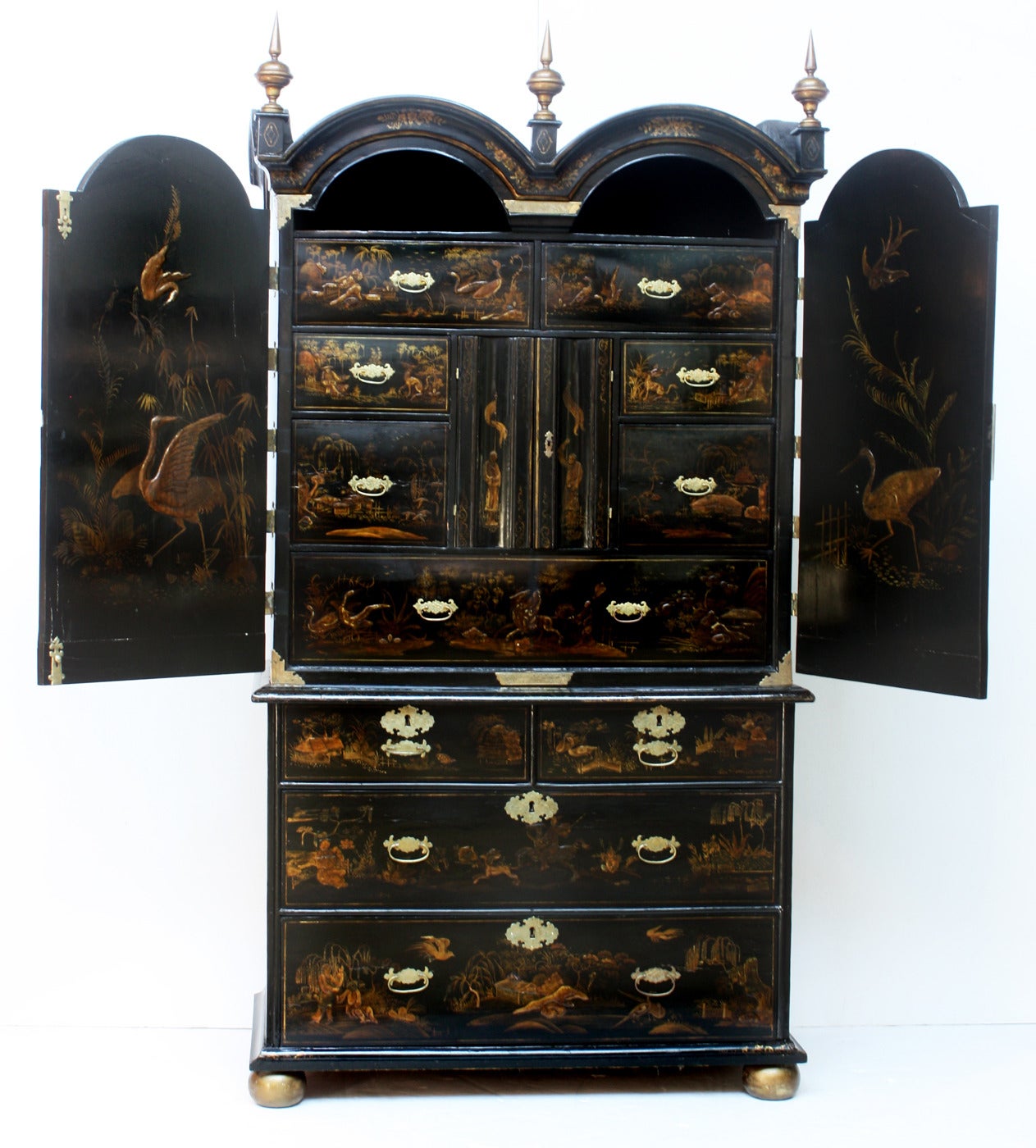A black lacquer secretary / cabinet with double arched bonnet / top with three finials and gilt Chinoiserie decoration.The bottom section is fitted with drawers, the upper section's interior is fitted out with many drawers and specialized
