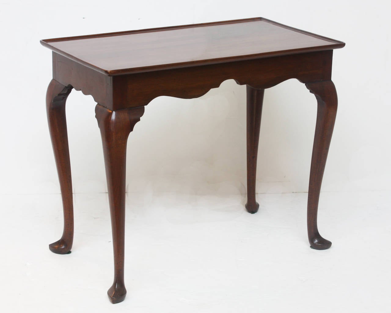 A Queen Anne Chippendale or Georgian mahogany tea table (rectangular) with scalloped apron, shaped cabriole legs and slipper feet