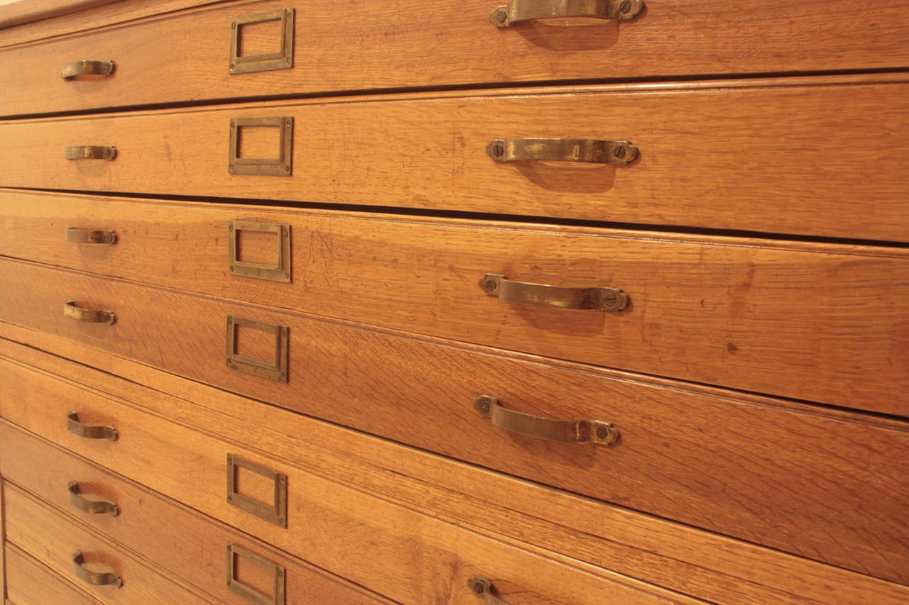 An English George VI period stacking map cabinet / architect's flat file. Two (2) section cabinet with four (4) drawers each. Solid quarter sawn oak drawer fronts with dove-tail construction and original brass hardware. The cabinet bears the English