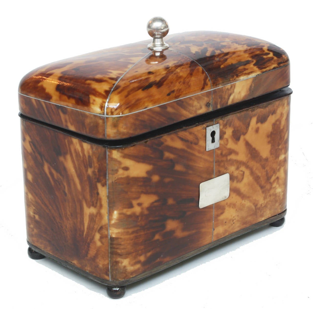 A wonderful English tortoiseshell tea caddy. The domed lid is decorated with silver stringing reaching from each corner to the central silver knob on top of the lid. There is also a silver mounted rectangular cartouche and escutcheon  in front. The
