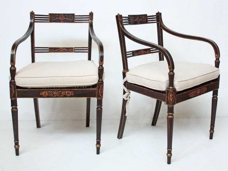 a pair of period English Regency black painted / ebonized chairs with gold trim and caned seats, off white cushions

seat height with cushion: 19.5
