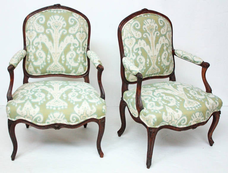 A pair of Louis XV beech wood open arm chairs. Some repairs and restoration. Newly upholstered.