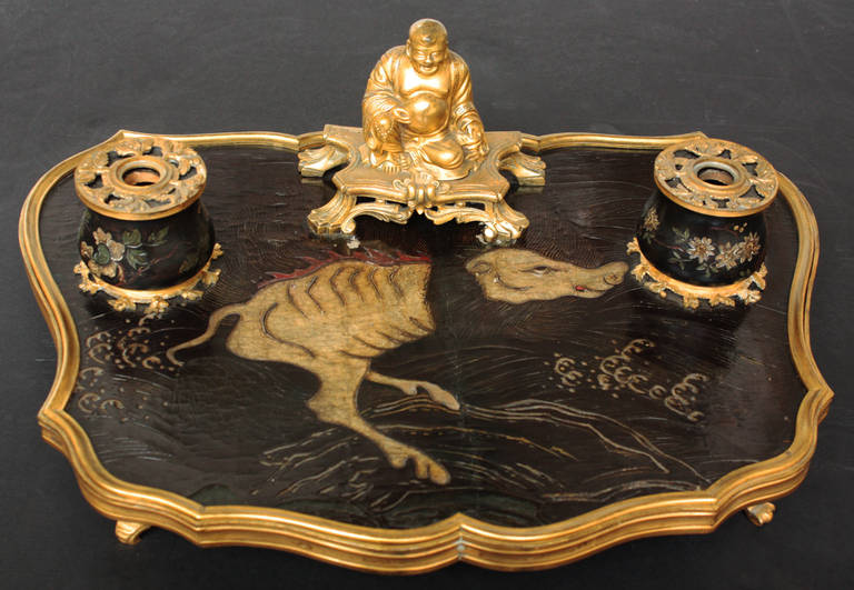 an 18th century French Rococo chinoiserie inkwell of gilt bronze with gilt bronze happy Buddha, black lacquer top with fantasy creature, some minor losses to lacquer top