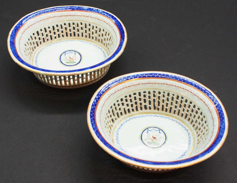a pair of Chinese reticulated bowls white, with blue, orange and gilt trim. Center circle with bird and tree. As found.
