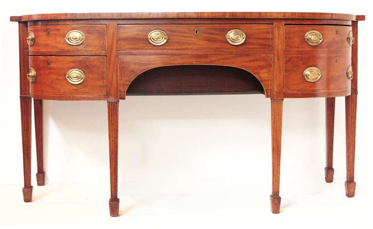 a Georgian sideboard of mahogany with concealed compartment behind center arched section having a lid formerly with a lock (missing), the whole 