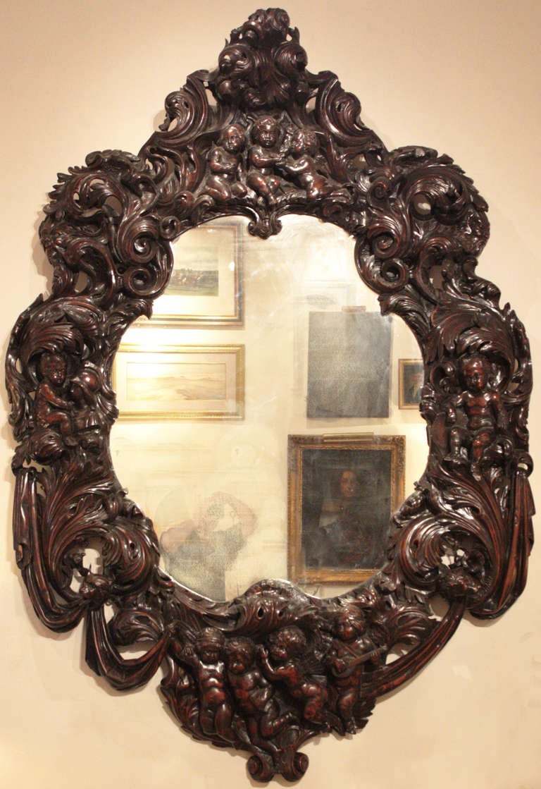 a large carved oval shape Rococo style mirror frame, deeply and elaborately carved with putti and leafy scrolls

Continental (?)

Possibly Paris Exposition 
second half of the 19th century