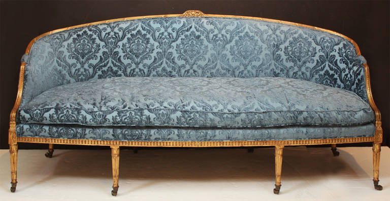 A period Adam sofa with carved gilt wood frame upholstered in blue cut velvet with casters. Placed in home by Jed Mace in 1962.