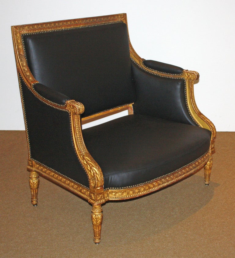 an oversized chair in the Louis XVI Revival manner, giltwood carved frame with black leather upholstery

38.25
