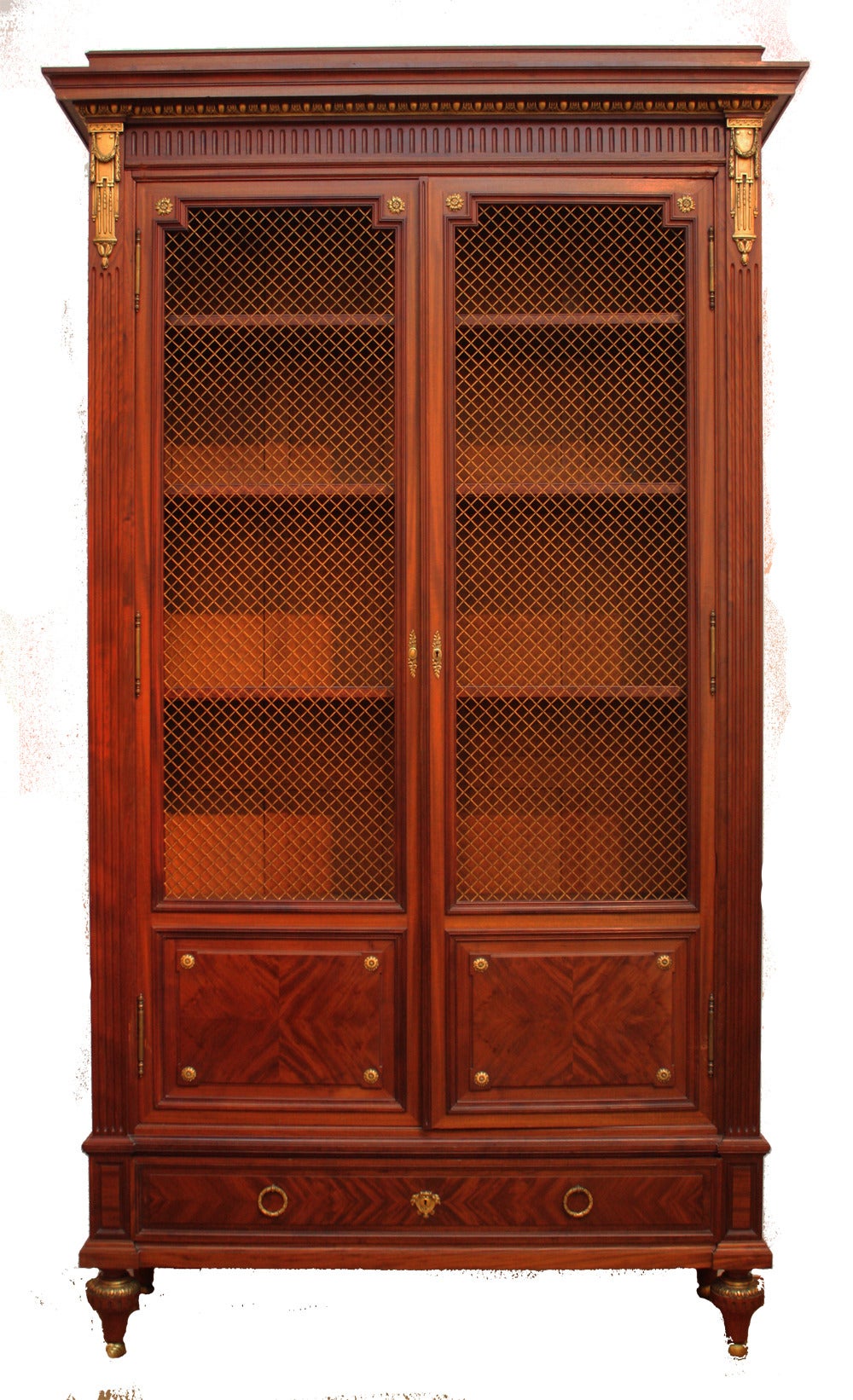 a monumental mahogany cabinet in the Neoclassical / Louis XVI manner, tall doors with brass grille inserts, flame veneer panels at bottom, ormolu mounts, the whole on trumpet feet, the Sormani mark is engraved on the lock plate (Image 4) 

PAUL