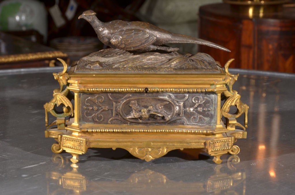 a box of gilt bronze and silvered bronze signed J. Moignez with a figural pheasant and sheaves of wheat on top, birds and bellflowers on ends and gargoyles at ends