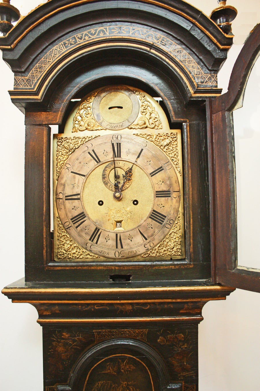 a George II black and gilt- japanned long case clock, arched bonnet supported  by columns and enclosing a circular dial with Roman and Arabic numerals. Inscribed Joseph Davis London (bottom of face) and Tempus Fugit or 