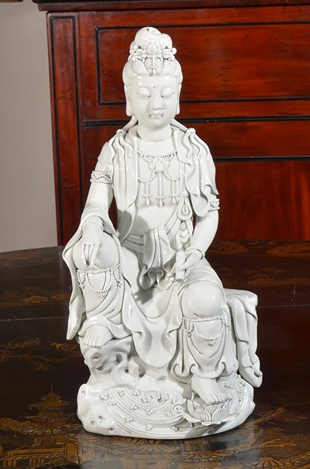 A Blanc de Chine model of Kwan-yin seated on a cloud with a scroll in hand. Incredible detail.