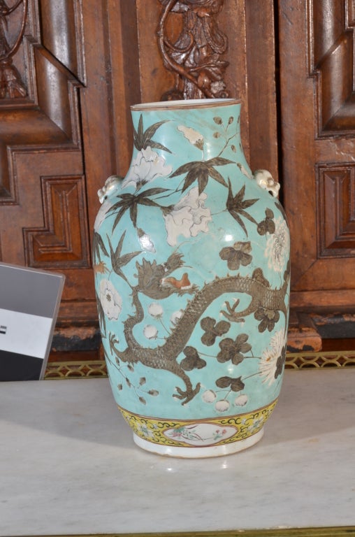 a Chinese vase, light blue green / turquoise with dancing dragon surrounded by white flowers
Dimensions: 12