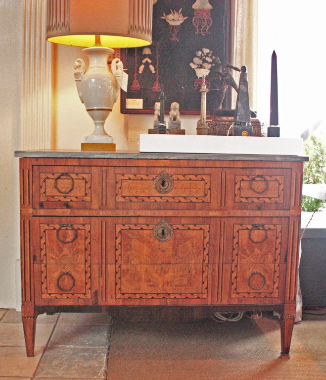 an Italian three drawer Louis XVI chest with marquetry and penwork on drawers and sides, grey marble top.