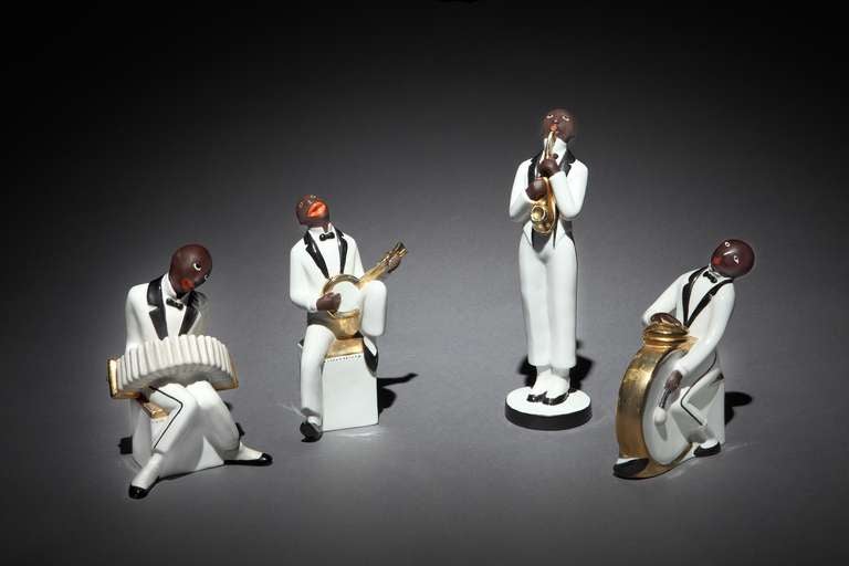 A very rare set of 4 Art Deco porcelain figures comprising a quartet of caricature black jazz musicians, namely accordionist, banjo player, saxophonist and drummer, playing their instruments. All signed ‘Robj, Paris’, French circa 1925. 

Height