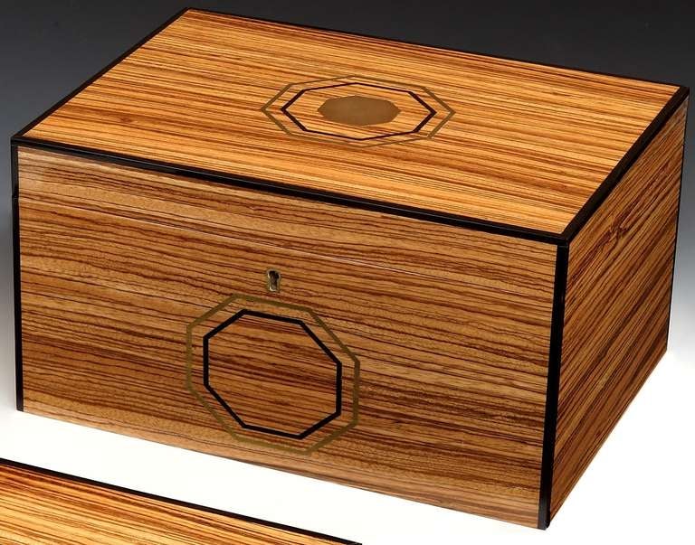 A very stylish, handmade humidor in highly polished zebrano wood, lined with Spanish cedar, the interior with a movable central divider and modern humidification system, capable of storing 75 cigars, the lid enhanced with an inlaid brass engraving