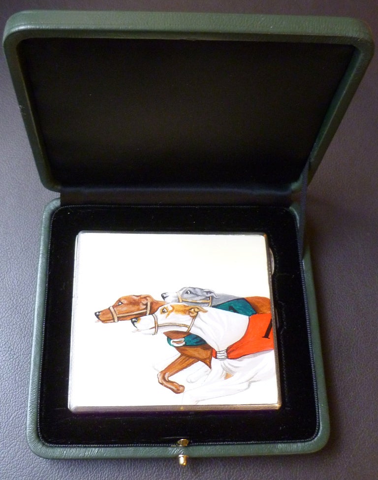 Of racing interest, a stylish Sterling silver and enamel Art Deco cigarette case with three racing greyhounds, each in a different coloured livery, all straining for the finish line. Hallmarked Birmingham 1930, complete with green calfskin box.