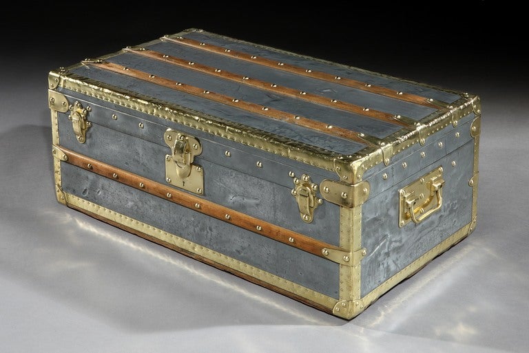 Vuitton, Paris: an extremely rare, and highly sought-after all-zinc covered small Malle Cabine (Cabin Trunk) with all brass trim, LV brass studs, and brass side handles and locks, with two wooden slats to the top, and a single slat to the front. The