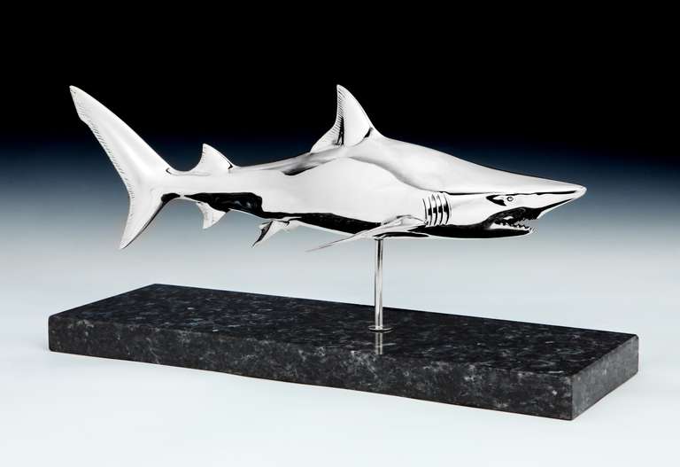 A finely observed Sterling silver model of a Reef shark, the sculpture set on a quartz plinth, the fins with stylized details and stamped STERLING 925 and with maker's stamp. 

Length overall: 20 inches (51 cms), width 6 inches (15 cms).