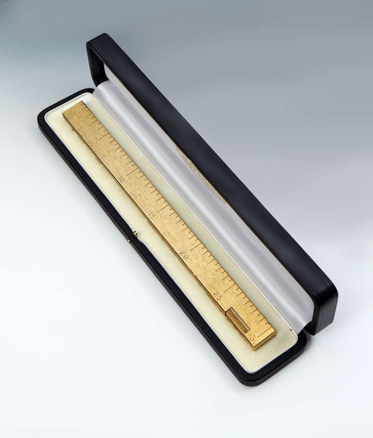A very stylish novelty table lighter in the form of a 12 inch (foot) ruler with (unusually) only inches marked on the rule, the body of the lighter with a brushed-gilt finish. Marked Dunhill, and Made in Switzerland. 

English, circa 1950,