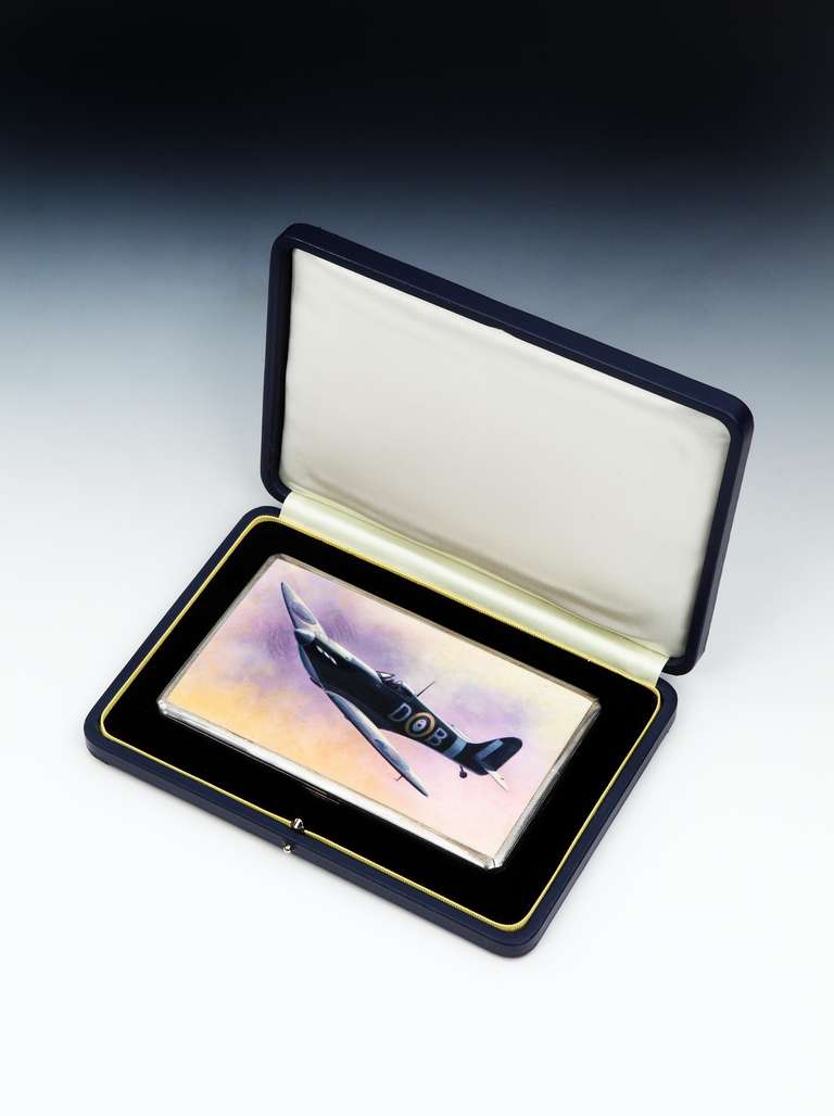 A very stylish, engine-turned cigarette case, dated 1945, with a large hand-painted panel applied to the front of a Spitfire in flight against a moody pink and blue sky. 

Hallmarked on the inside with Birmingham marks for 1945, with the painted