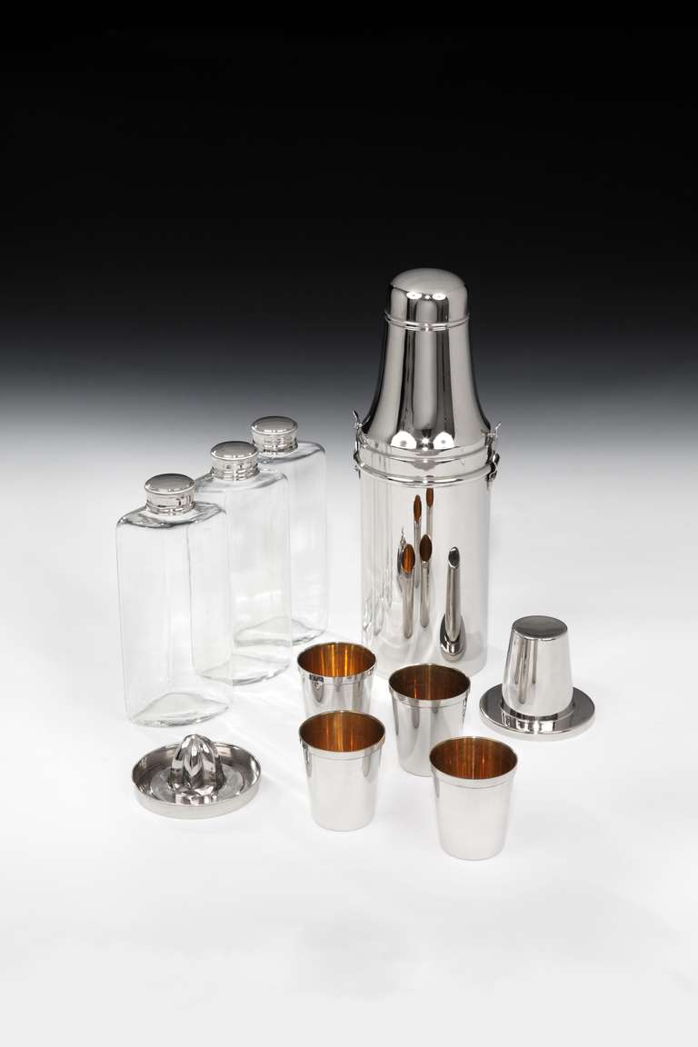 An impressive nickel-plated travelling cocktail compendium in the form of a 1930’s milk bottle, all-complete and comprising of three glass spirit flasks with screw caps, a stacking set of four beakers with gilded interiors, a double cocktail jigger