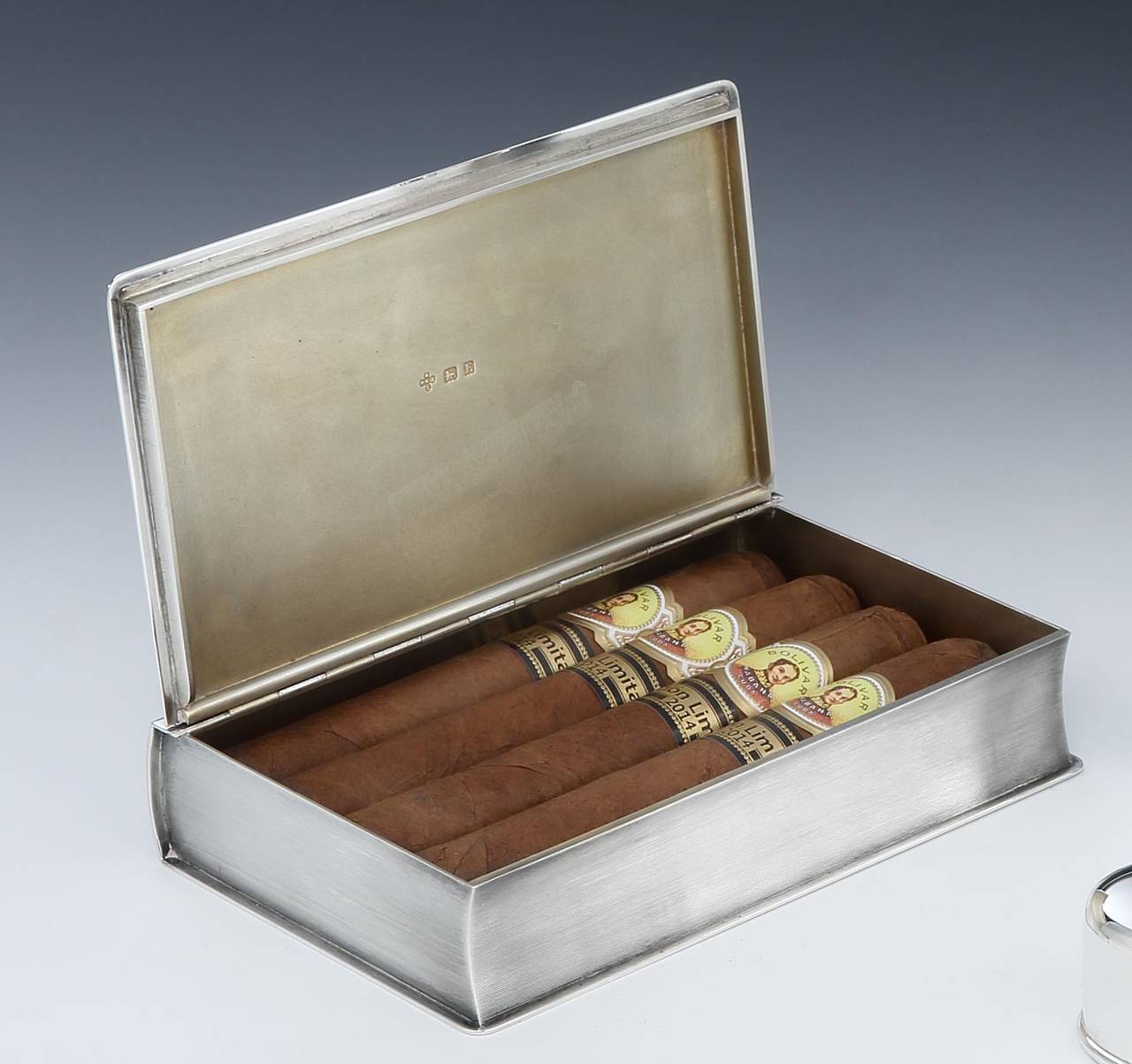 William Base and Sons of Birmingham.

A Sterling silver novelty cigarette or cigar box in the form of a bound book, with engine turning to the main body, with plain silver corners, silver-gilt interior and two plain bands to the ‘spine’, perfect