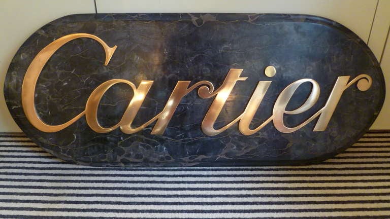 A very stylish and massive shopfront sign for Cartier, the lettering in polished and lacquered bronze, and mounted on a figured marble plaque, with swept edges. With mirror plate fixings to the reverse enabling it to be wall mounted.

Information