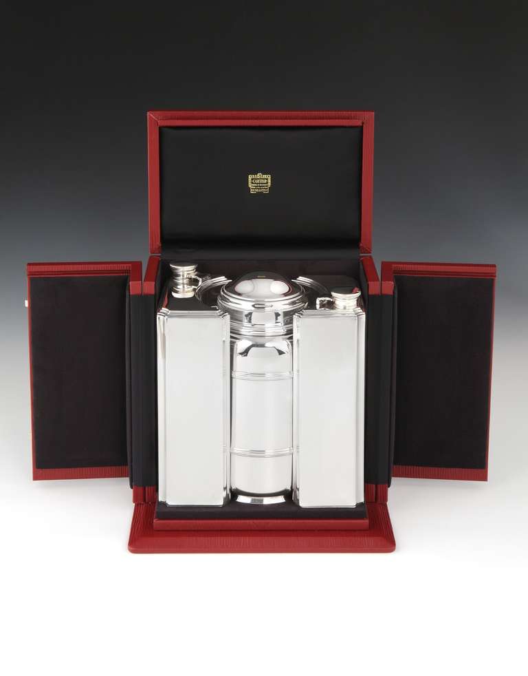 An extraordinarily rare and ingenious Art Deco Sterling silver travelling cocktail set by Cartier of Paris, comprising of two, 2-pint capacity spirit flasks, flanking a central covered container, which assembles into a long-necked cocktail shaker,