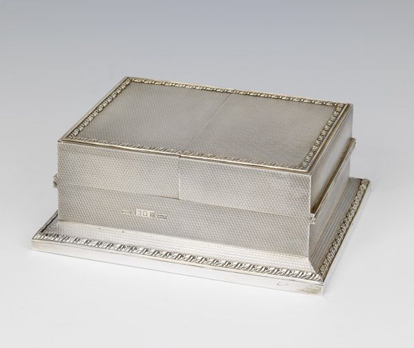 A very fine quality, engine-turned Sterling silver playing-card box, the top with ornate beaded edging in silver-gilt, hinged on both sides opening to reveal a gilded interior with compartments for two decks of playing cards, with ornate pierced