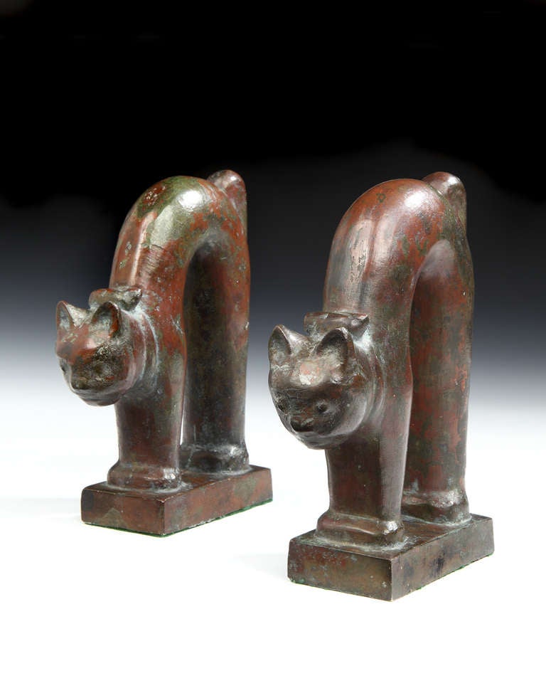 An unusual pair of Art Deco, patinated bronze bookends in the form of stylized, stretching cats.