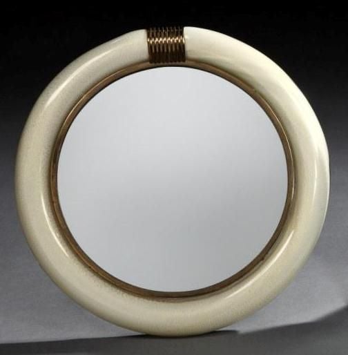 A very stylish vanity mirror, the wide circular border of hand-blown Murano glass, white with a gold fleck running through, with decorative bronze detailing, and geometric easel back.