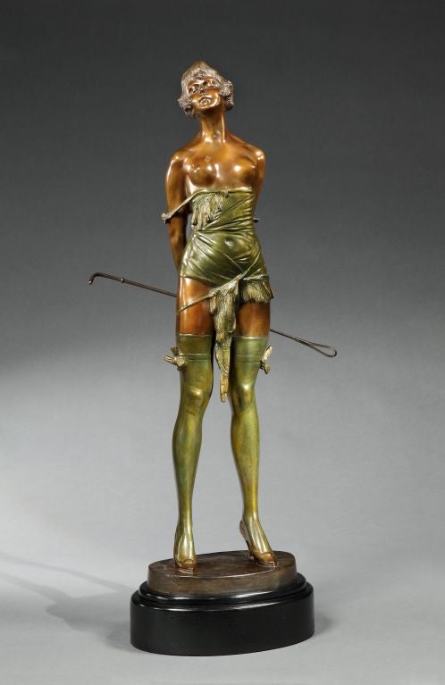 An extremely rare, large bronze figure of a dominatrix holding her riding crop behind her back, her garments patinated, with torso in polished bronze with cold painted highlights, signed Bruno Zach and bearing monogram, on a black marble oval base,