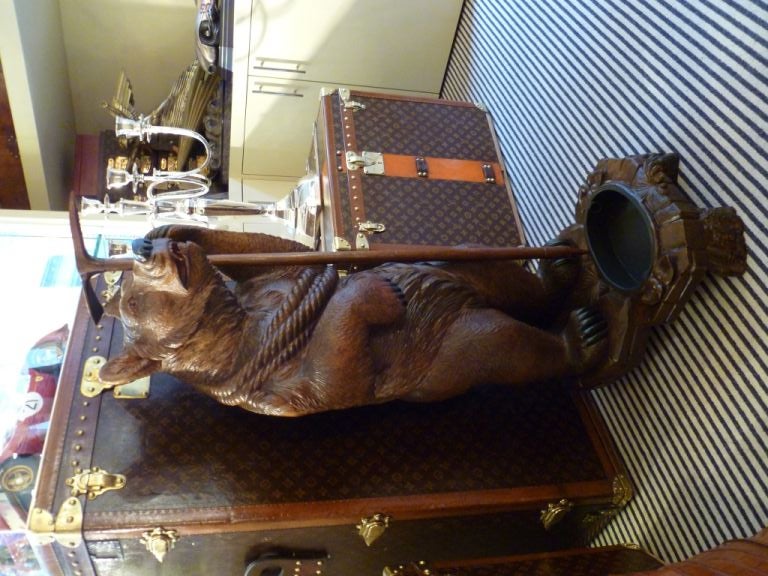 A superb 19th century Black Forest carved walnut stick or umbrella stand, in the form of a mountaineering black bear, holding a climbing rope and ice pick, with metal tray to the base.