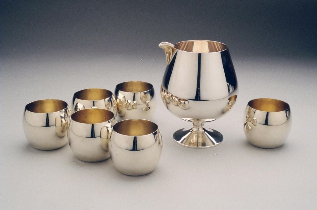 A Sterling silver Martini Set comprising a Sterling silver pitcher and 6 cups with silver gilt interiors, weighing 1035 grams of silver, each item carrying the mark of Tiffany & Co., and STERLING. <br />
<br />
Size of pitcher: 13 cms tall and 11