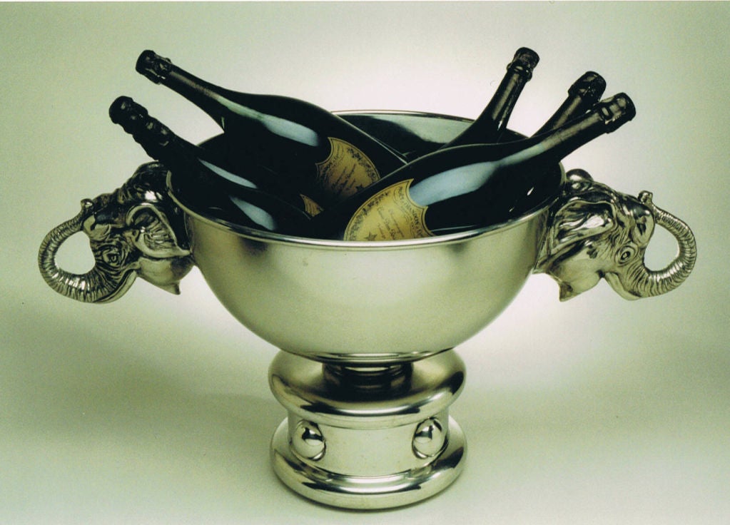 Striking silver plated Champagne or wine cooler of massive proportions, the heavy cast base resembling a circus drum. Finely detailed silver bronze carrying handles, in the shape of elephant heads, complement the circus theme.