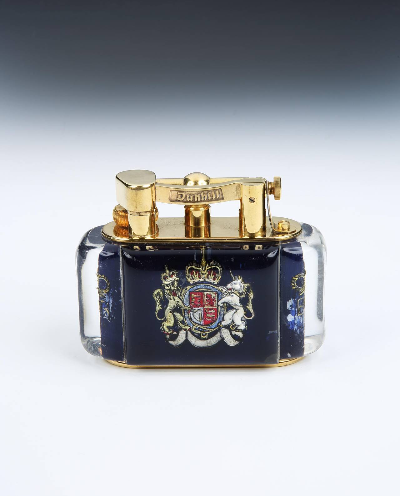 A very rare, and most likely unique gold-plated 'Aquarium' table lighter, the perspex body enclosing a hand-painted English Royal coat of arms to the front and reverse, using the highly skilled intaglio technique, where the design is built up in