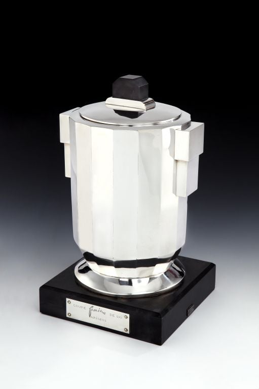 A very stylish silver-plated Art Deco trophy cup and cover with lid, the facetted body mounted on a thick black marble base, the lid with matching black Bakelite finial, with stepped Art Deco handles to each side. Bearing silver plaque to the front