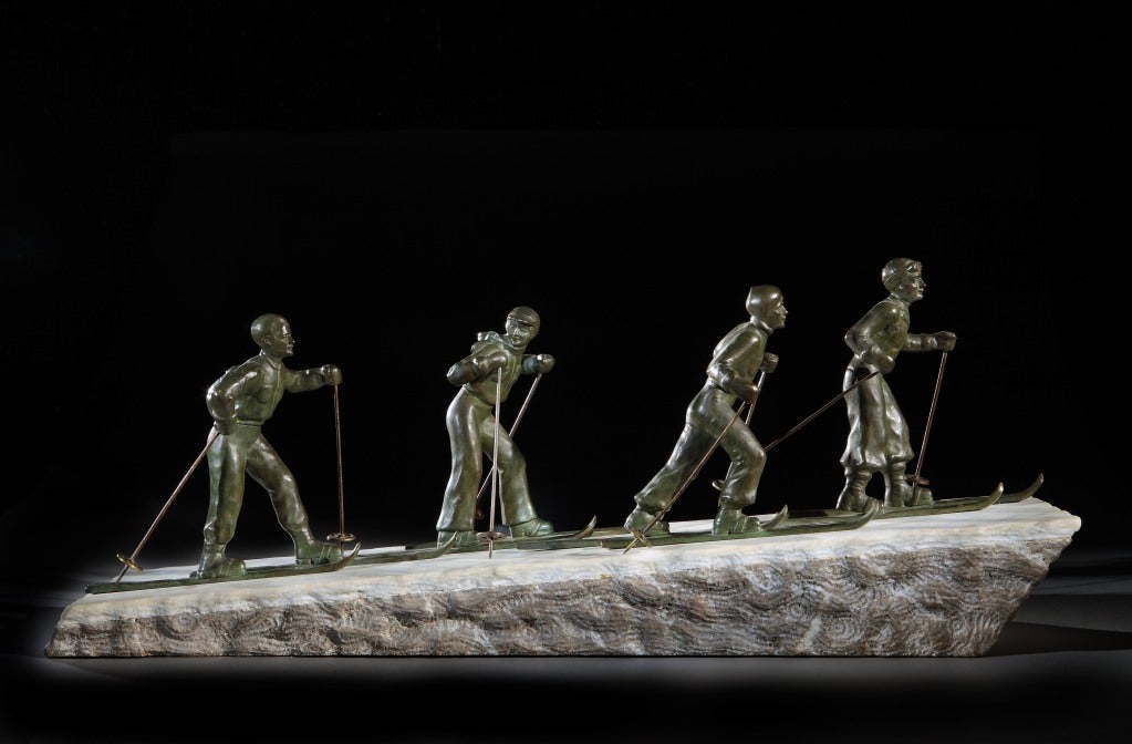 ‘Les Skiers’ a large and very stylish Art Deco bronze, circa 1925, depicting a group of four skiers in Art Deco ski outfits, ascending a slope, the layered, angled base in hewn granite, with white marble ‘snow’ each skier marked BRONZE, the marble