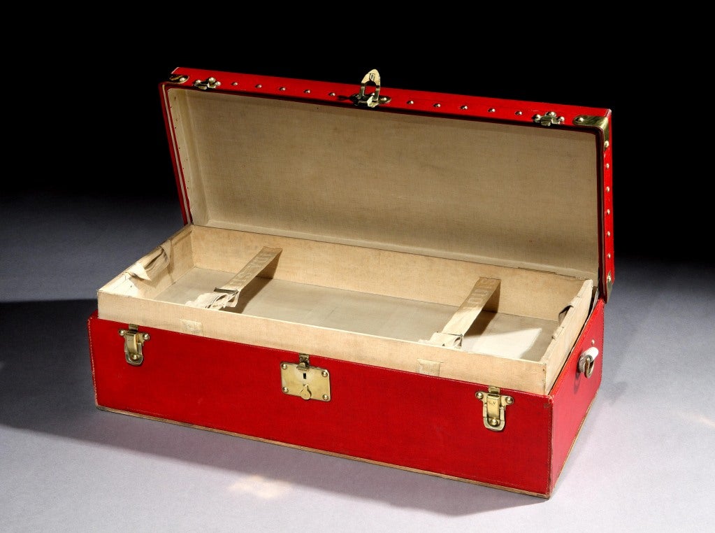 An exceptional and all original red Vuittonite canvas 'Malle Auto' (car trunk) by Louis Vuitton, circa 1906, with all brass binding, corners, latches and studs, with brass looped handles to each side, the interior with original lift-out tray and