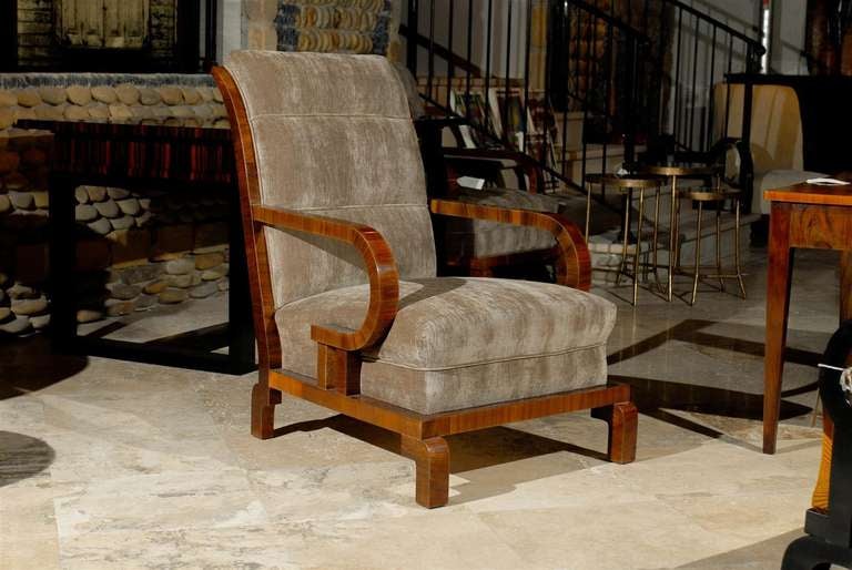 A pair of 1930s Art Deco period upholstered walnut club chairs with gooseneck-form arms from Hungary. Each chair is covered in a smoky brown velour and features a slightly slanted out-scrolled back providing great comfort for the sitter. The general