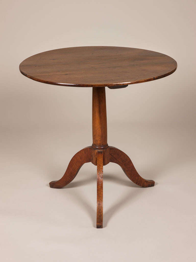 An early 19th century French walnut tripod table with a circular plank top and turned support.