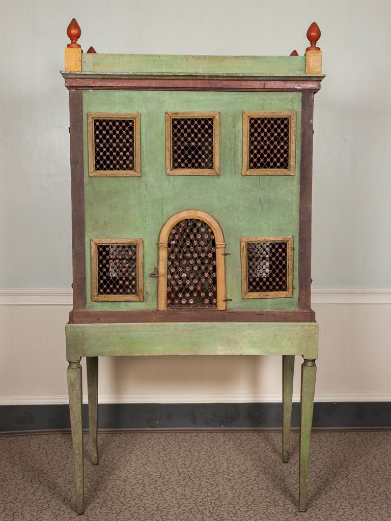 A 19th century Italian painted folk art birdcage in the form of a house with an arcaded interior.