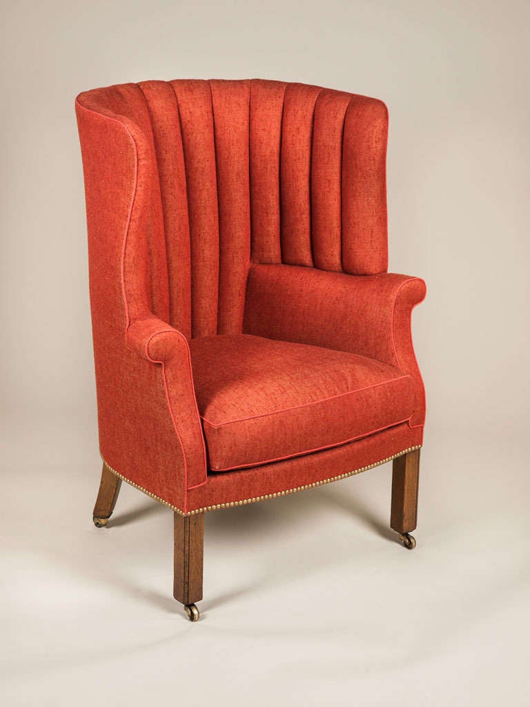 A late 19th century wing chair with fluted barrel back and square section mahogany legs.