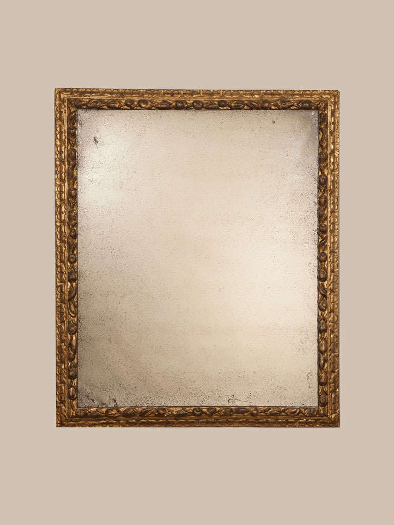 A large late 17th or early 18th century finely carved giltwood frame, probably Italian, with a modern mirror plate.